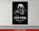 a poster of a skull with a barbell on a brick wall
