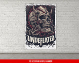 a white brick wall with a poster of a skull and a demon on it