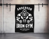 Black gym towel with a muscular gorilla and "ANDERSON IRON GYM NO EXCUSES EST 2026".