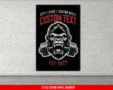 a gorilla with a barbell in his mouth on a brick wall