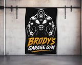 Gorilla flexing muscles above "Brody's Garage Gym" text on a black banner.