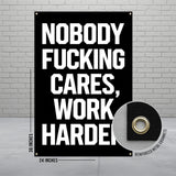 Black banner with bold white text "NOBODY FUCKING CARES, WORK HARDER" and grommets.