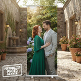 A couple embracing in a garden setting, with a stone building and potted plants in the background.