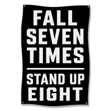 Black banner with white text that reads: Fall Seven Times, Stand Up Eight.