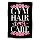 Black flag with "GYM HAIR don't CARE" text surrounded by pink floral accents.